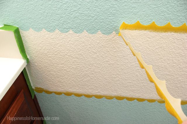 scallop shaped tape being peeled off of diy wall