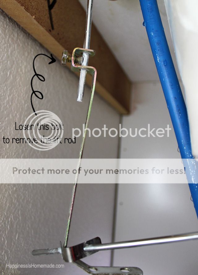 under sink shown with arrow drawn showing what bolt to loosen to lift rod to change sink faucet