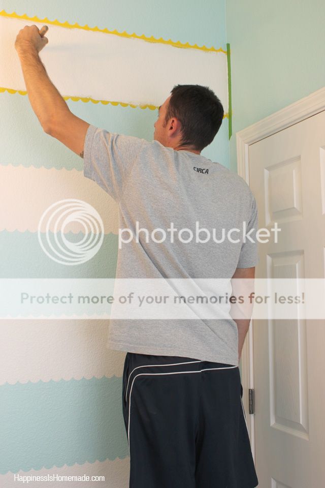 man removing tape from finished wall